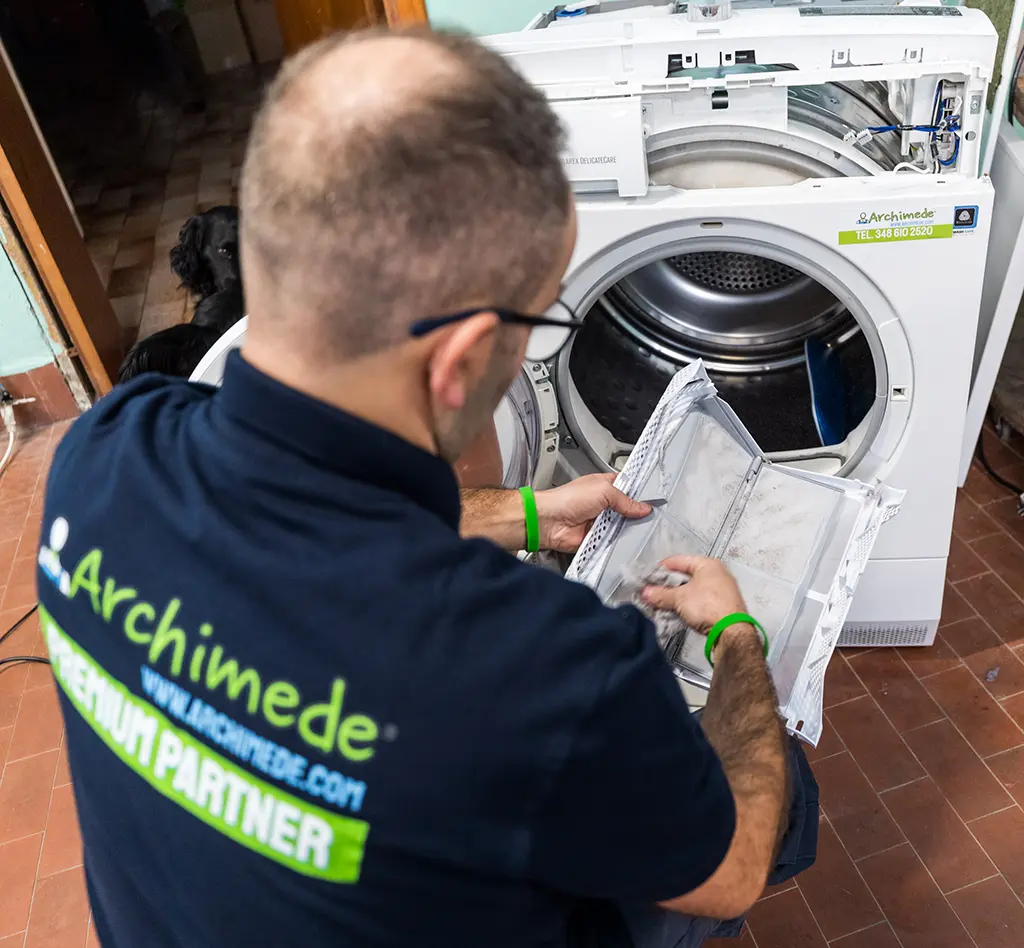 Tecnico ARCHIMEDE controlla i componenti interni di un'asciugatrice a Brescia