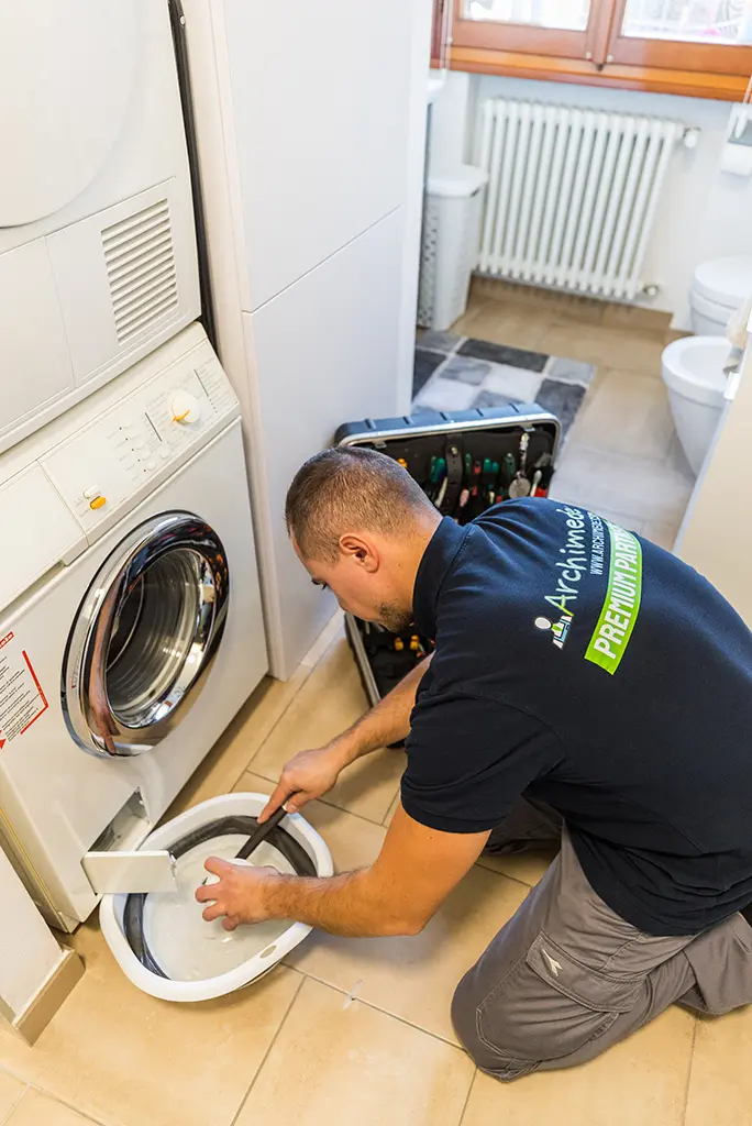 Tecnico ARCHIMEDE controlla i componenti interni di una lavatrice a Brescia