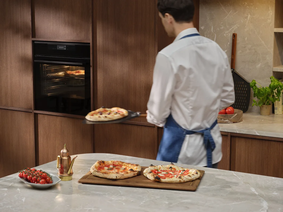 Pizze servite su un tagliere e su piatti in una cucina domestica