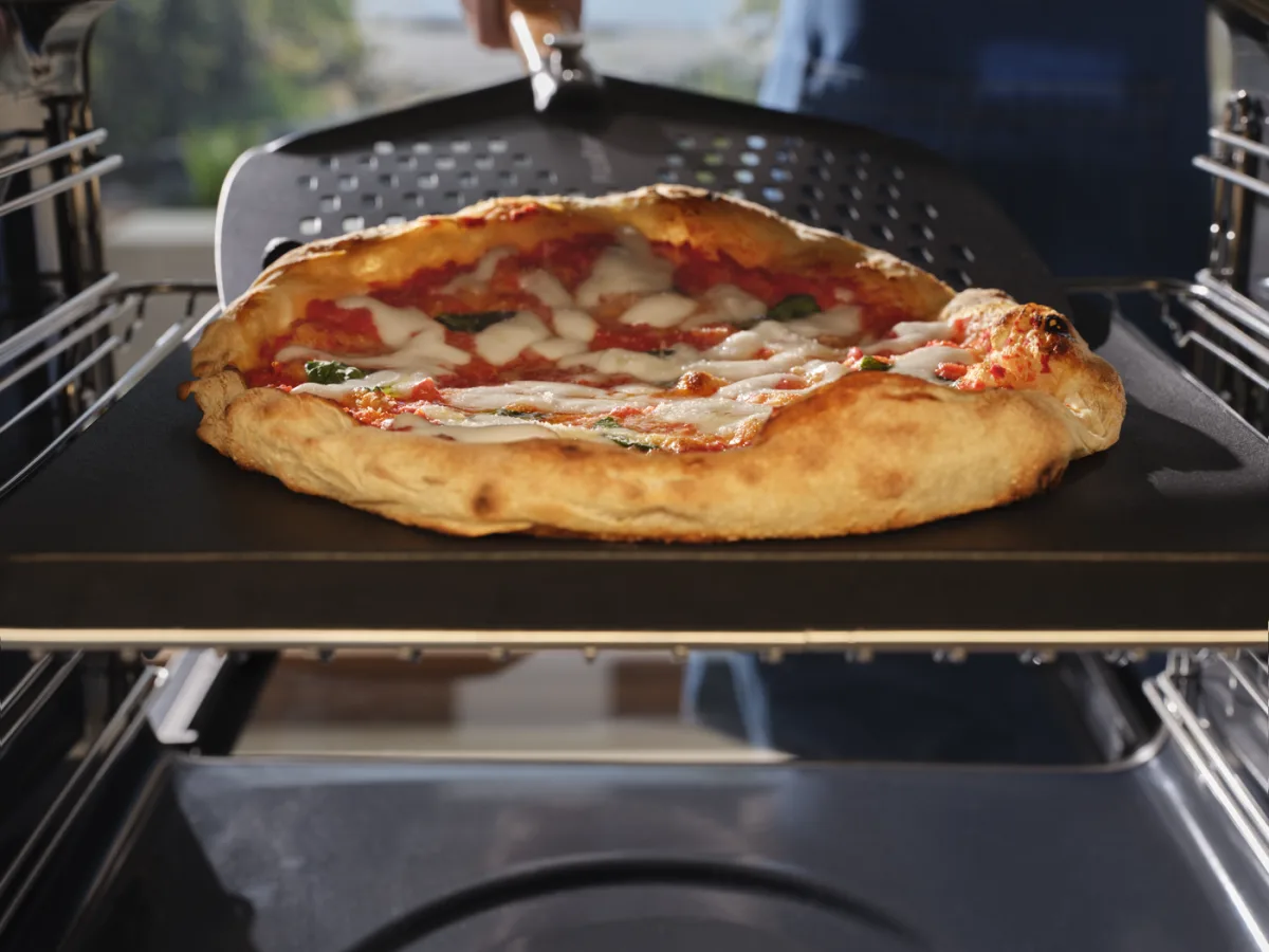 Pala forata Electrolux che sforna una pizza dal forno PizzaExpert Serie 700
