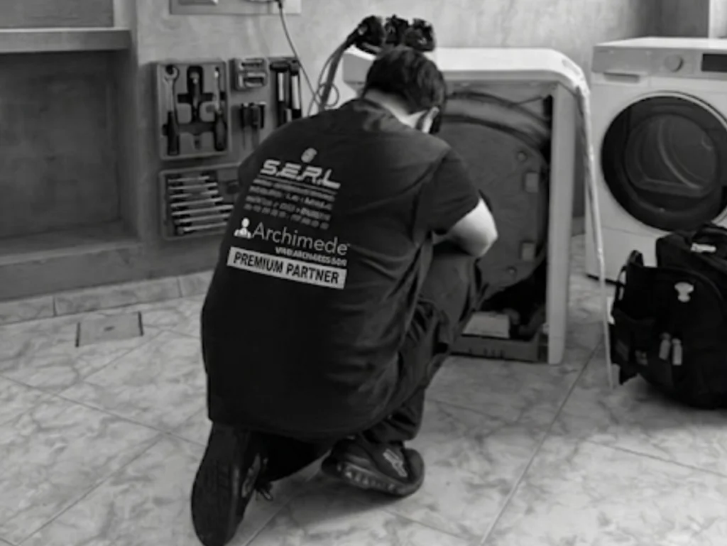Riparazione lavatrice a Napoli: tecnico S.E.R.L. al lavoro sui componenti interni dal retro